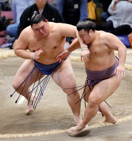 大の里（左）が押し出しで翔猿を下す＝福岡国際センター