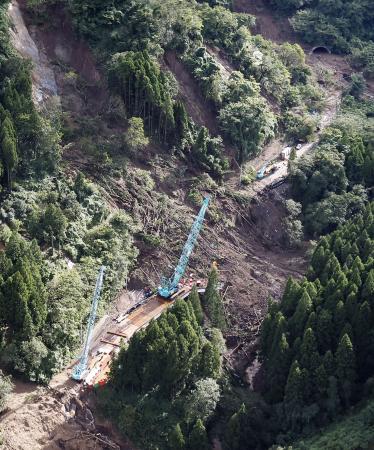 土砂崩落が起きた石川県輪島市の国道２４９号中屋トンネル（右上）の復旧工事現場＝９月２２日