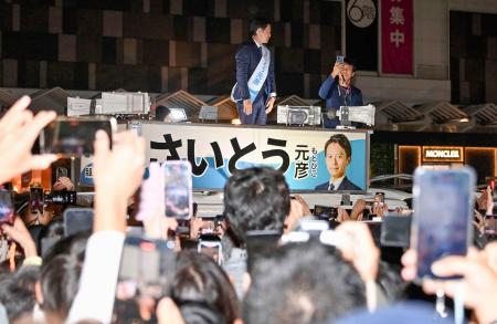 兵庫県知事選の選挙戦最終日、スマートフォンを掲げる大勢の有権者の前で街頭演説する斎藤元彦氏＝１６日、神戸市