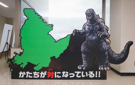 佐賀県庁に展示された、左に９０度傾けた佐賀県の形と「ゴジラ」の形を比較するパネル＝２７日午後（ＴＭ　＆　（Ｃ）　ＴＯＨＯ　ＣＯ．，　ＬＴＤ．）