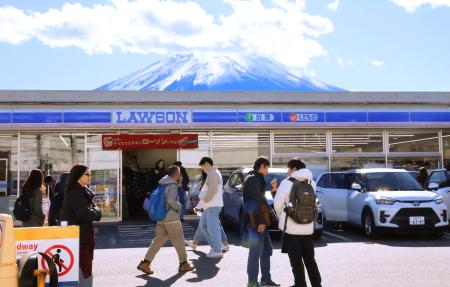 屋根越しに富士山を撮影できるとして訪日観光客らが集まるコンビニ＝２９日午後、山梨県富士河口湖町