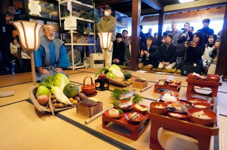 奥能登の農家に伝わる農耕儀礼「あえのこと」で「田の神様」に酒やごちそうを振る舞う小山栄さん。日本の「伝統的酒造り」や「あえのこと」はユネスコの無形文化遺産に登録されている＝５日午後、石川県輪島市三井町