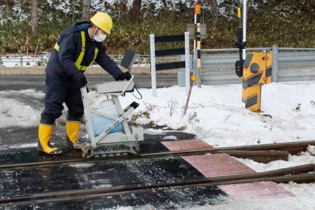 超音波探傷器を使って踏切のレールを調べるＪＲ北海道の担当者＝１０日午後、北海道小樽市