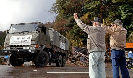 石川県珠洲市大谷地区での陸上自衛隊の支援活動が終了し、車両を手を振って見送る住民＝１７日午前