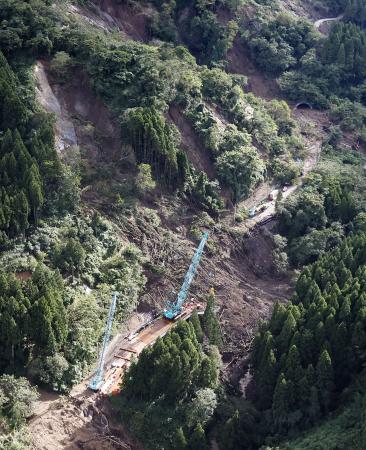 地震の復旧工事のさなかに、記録的豪雨による土砂崩落が起きた石川県輪島市の国道２４９号「中屋トンネル」（右上）＝９月