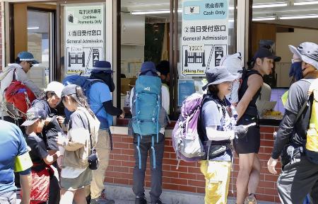 ８月、富士山の山梨県側登山道「吉田ルート」の５合目で規制ゲートの受付に並ぶ登山客