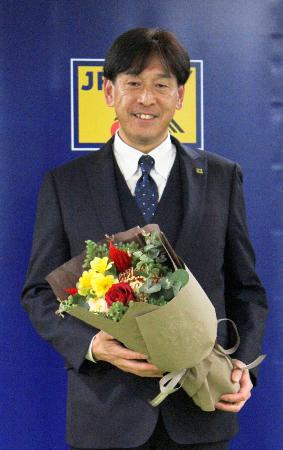 花束を手に写真に納まるサッカーの元国際審判員の西村雄一氏＝１９日、東京都文京区