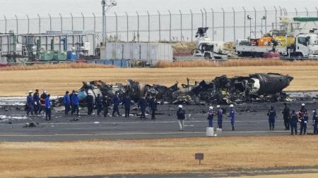 焼け焦げた海上保安庁の航空機周辺に集まる警視庁の捜査員や東京消防庁の隊員ら＝１月、羽田空港