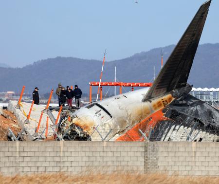 ３１日、韓国南西部の務安国際空港で事故機を調べる米国の運輸安全委員会の関係者ら（聯合＝共同）