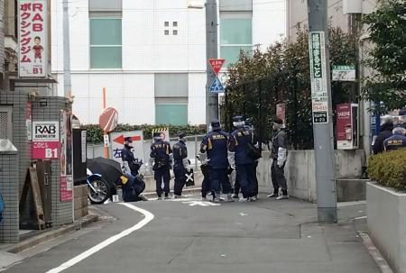 女性が刺された現場付近を調べる捜査員＝１１日午前１１時３９分、東京都新宿区